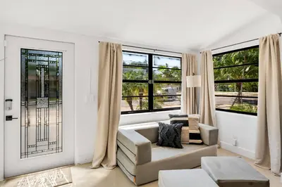 a living room with a couch and two windows at Urban Seaside in Dania Beach
