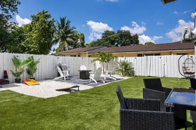 a backyard with a white fence and chairs at Coco Loco - Little Havana in Miami