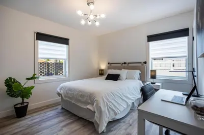 a bedroom with a bed and a desk and two windows at Coco Loco - Little Havana in Miami