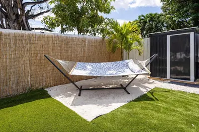 a hammock sitting in a yard next to a fence at Coco Loco - Little Havana in Miami