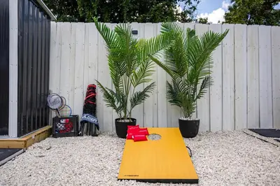 a yellow table in front of a fence with two plants at Coco Loco - Little Havana in Miami