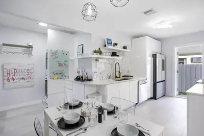 a white kitchen with a table and chairs in it at Coco Loco - Little Havana in Miami