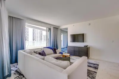 a living room with a white couch and a tv at Fort Lauderdale Condo with Veranda and Ocean View! in Fort Lauderdale