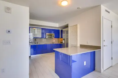 a blue kitchen with white walls and blue cabinets at Fort Lauderdale Condo with Veranda and Ocean View! in Fort Lauderdale