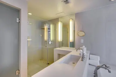 a white bathroom with a tub and a shower at Fort Lauderdale Condo with Veranda and Ocean View! in Fort Lauderdale