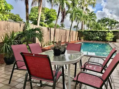 a patio with a table and chairs next to a pool at Pool House in Tropical Miami in Miami