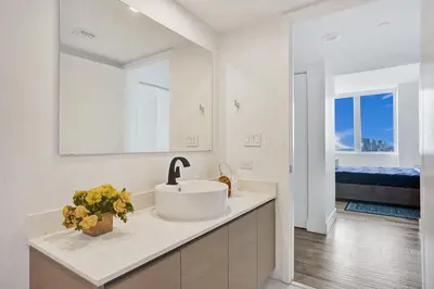 a white bathroom with a sink and a mirror at Lower Penthouse 3BD 3BA - Beach Pool Gym in Hallandale Beach