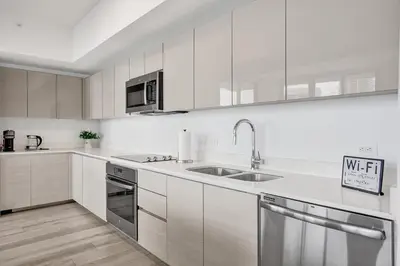 a kitchen with white cabinets and stainless steel appliances at Lower Penthouse 3BD 3BA - Beach Pool Gym in Hallandale Beach