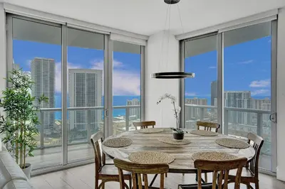a dining room with a table and views of the city at Lower Penthouse 3BD 3BA - Beach Pool Gym in Hallandale Beach