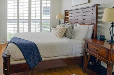 a bedroom with a bed with a wooden headboard and a table at 1bed 1bath Steps To Marina & Cocowalk In Grove in Miami