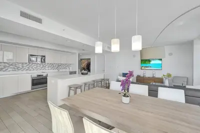 a dining room and kitchen with a table and chairs at Modern Ocean View 3 Bedroom Condo Resort Amenities in Hallandale Beach