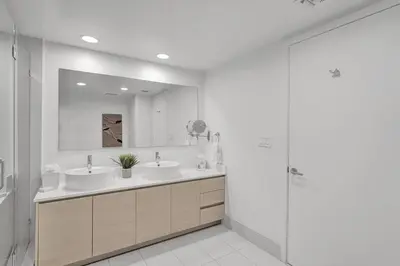 a bathroom with two sinks and a mirror at Modern Ocean View 3 Bedroom Condo Resort Amenities in Hallandale Beach