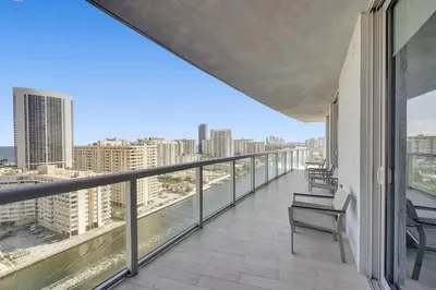 a balcony with chairs and a view of the city at Modern Ocean View 3 Bedroom Condo Resort Amenities in Hallandale Beach