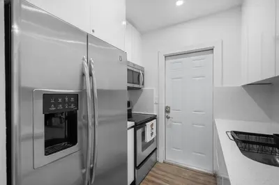 a kitchen with a stainless steel refrigerator and a door at Villa Mia Cozy Home in the heart of Miami in Miami
