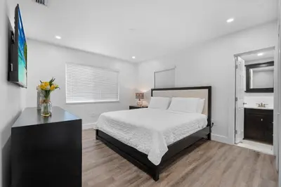 a white bedroom with a bed and a sink at Villa Mia Cozy Home in the heart of Miami in Miami