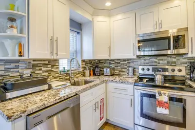 a kitchen with white cabinets and stainless steel appliances at Private Pool and Patio Fort Lauderdale Home! in Fort Lauderdale