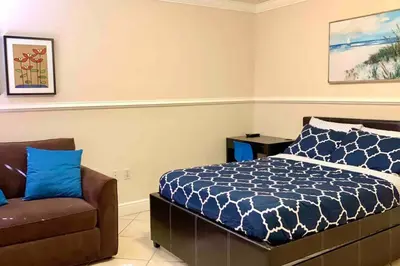 a bedroom with a bed and a chair at Tropical Oasis home w Community Pool great area in Kendall