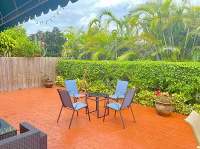 a patio with four chairs and a table and a fence at Tropical Oasis home w Community Pool great area in Kendall