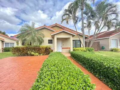 a house with palm trees and a red brick driveway at Tropical Oasis home w Community Pool great area in Kendall
