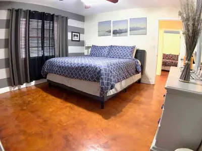 a bedroom with a bed and a wooden floor at HOME AWAY FROM HOME Near Airport and Malls and Highways in South Miami