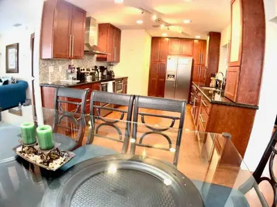 a kitchen with a glass table and chairs in a kitchen at HOME AWAY FROM HOME Near Airport and Malls and Highways in South Miami