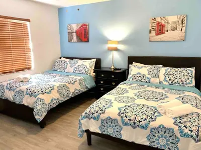 two beds in a bedroom with blue walls at Home Sweet Home Near Malls and Airport and Hwy in South Miami