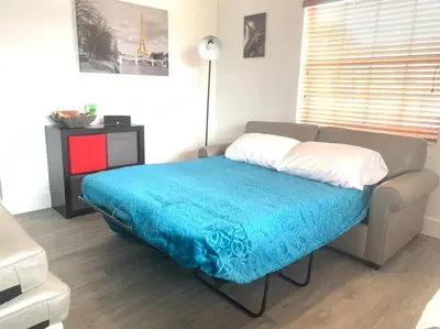 a bedroom with a couch with a blue blanket at Home Sweet Home Near Malls and Airport and Hwy in South Miami