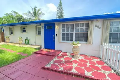 a house with a blue door and a red patio at Great location Pool home w Pool table 5br in Fort Lauderdale