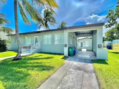 a house with a palm tree in front of it at Villa Gia Large Home Near Brickell Miami Beach in Miami