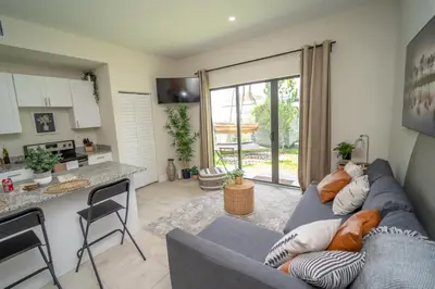 a living room with a blue couch and a kitchen at Miami Luxury 5BD Home! Next to Wynwood & Design district in Miami