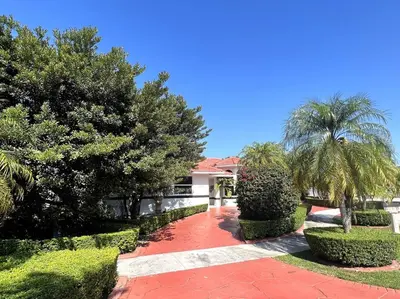 a red brick walkway with trees and palm trees at Sunny Getaway: Relaxing Miami Home in Tamiami