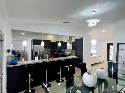 a kitchen with a counter and some chairs in it at Sunny Getaway: Relaxing Miami Home in Tamiami