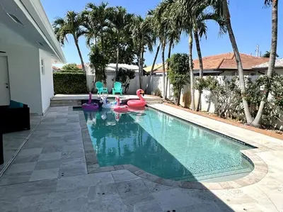 a swimming pool with swans and chairs in a house at Sunny Getaway: Relaxing Miami Home in Tamiami