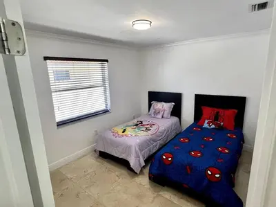 a small bedroom with a bed and a window at Sunny Getaway: Relaxing Miami Home in Tamiami