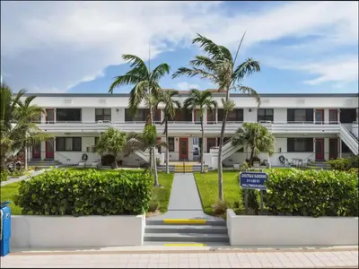 a white building with palm trees in front of it at 311-22 Beachside in Hollywood
