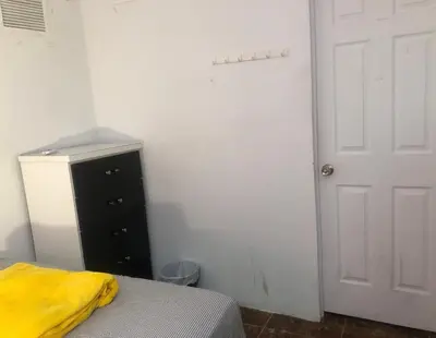 a bedroom with a bed and a dresser and a door at Miami House in Miami