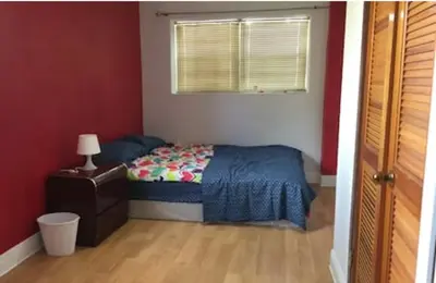 a small bedroom with a bed and a window at Miami House in Miami