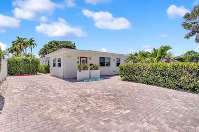 a white house with palm trees in front of it at Soleil @ Casa Del Sol in Fort Lauderdale