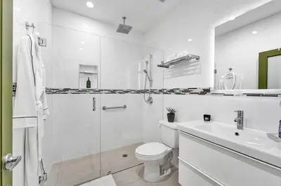 a white bathroom with a toilet and a sink at SOBE Monarch 1 - 2 BEDROOM 2 BATHROOM - MODERN APTS -WALK TO OCEAN DRIVE -2 INDEPENDENT 1 BEDROOM 1 BATHROOM APTS in Miami Beach