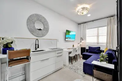a kitchen and living room with a blue couch at SOBE Monarch 1 - 2 BEDROOM 2 BATHROOM - MODERN APTS -WALK TO OCEAN DRIVE -2 INDEPENDENT 1 BEDROOM 1 BATHROOM APTS in Miami Beach