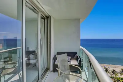 a balcony with a table and chairs and the ocean at Beautiful 1 1 Beach View 14 Floor in Hollywood