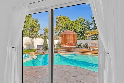 a view of a swimming pool through a sliding glass door at Luxury Hollywood Home, Heated Pool, Casino Nearby in Hollywood
