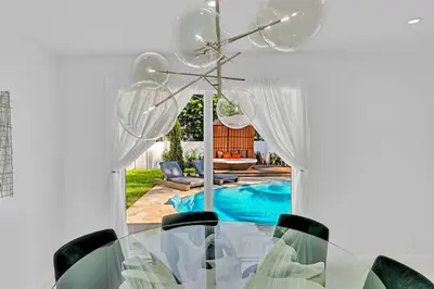 a dining room with a table and chairs and a pool at Luxury Hollywood Home, Heated Pool, Casino Nearby in Hollywood