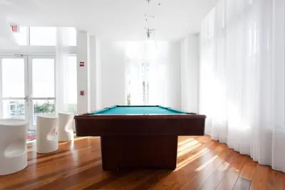 a room with a pool table and two white chairs at Contemporary Loft in Beautiful Down 4 people 1608 in Miami