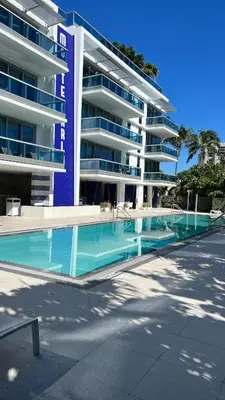 a swimming pool in front of a large building at Monte Carlo by Miami Ambassadors in Miami Beach