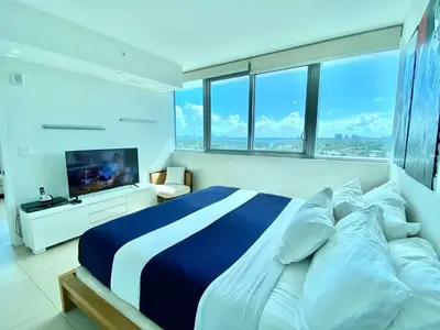 a bedroom with a large bed and a television at Monte Carlo by Miami Ambassadors in Miami Beach