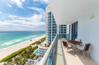 a balcony with a table and chairs and a view of the beach at Monte Carlo by Miami Ambassadors in Miami Beach