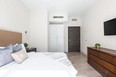 a bedroom with a white bed and a flat screen tv at Cozy Apartment - Hollywood Beach - Amazing Pool in Hollywood