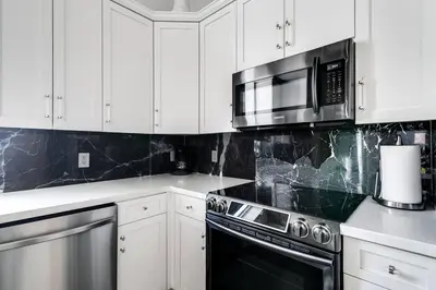 a kitchen with white cabinets and a stove and microwave at Spectacular 2-Br Apartment 4 people 1107 in Miami