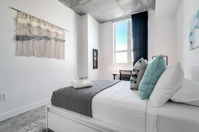 a white bedroom with a large bed with pillows at Spectacular 2-Br Apartment 4 people 1107 in Miami